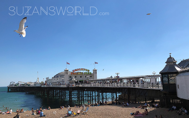 The Brighton Palace Pier on a bright sunny day with people on the beach in front